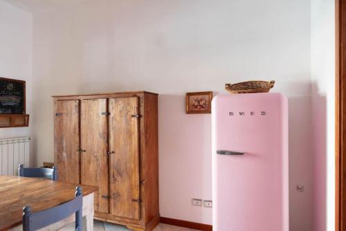 a kitchen with a pink refrigerator and a wooden cabinet at Cosy Vibes Rieti in Rieti