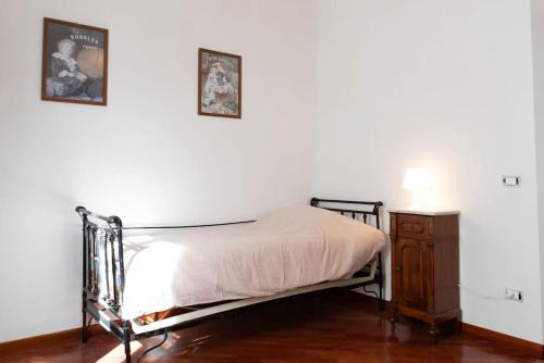 a bed and a night stand in a room with a white wall at Cosy Vibes Rieti in Rieti