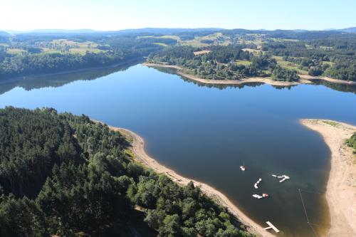 une vue aérienne sur un lac avec des bateaux dans l'eau dans l'établissement Le GIte de Lavalette, à Lapte