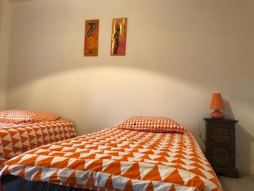 une chambre avec deux lits jumeaux et une table de chevet dans l'établissement Le GIte de Lavalette, à Lapte