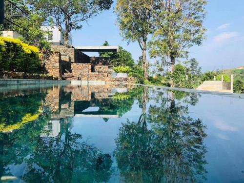 a pool of water in front of a house at Romance Valley Haputale in Haputale
