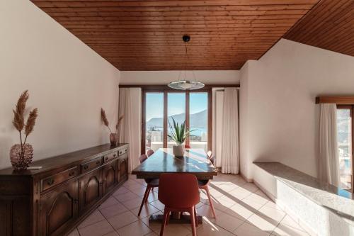 a dining room with a wooden ceiling and a table and chairs at Miralago by Quokka 360 - flat in the gulf of Melano in Melano