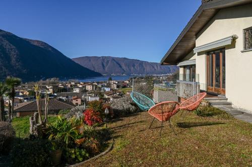 two chairs sitting on a yard next to a house at Miralago by Quokka 360 - flat in the gulf of Melano in Melano