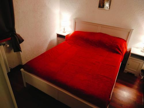 een rood bed in een kamer met twee nachtkastjes bij Mirtilli in Prato Nevoso