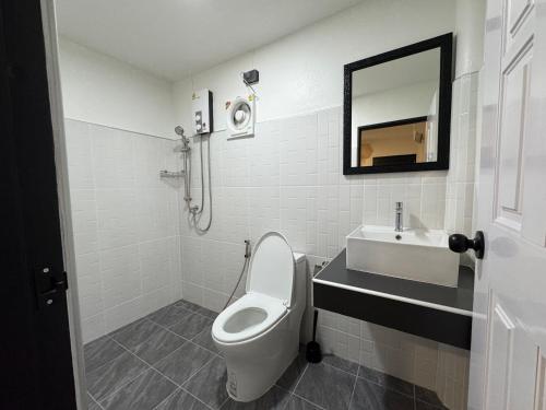 a bathroom with a toilet and a sink and a mirror at 7Senses Resort in Ko Chang