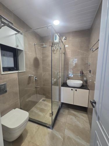 a bathroom with a shower and a toilet and a sink at Satish Villa in Hyderabad