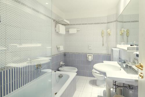 a bathroom with a tub and a toilet and a sink at Hotel Plaza in Mestre