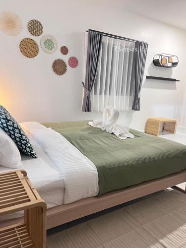 a bedroom with a large bed with green and white sheets at 7Senses Resort in Ko Chang