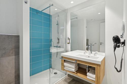 une salle de bain avec un lavabo et une douche dans l'établissement Akena Nantes Rezé Aéroport, à Rezé