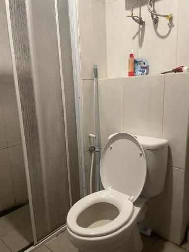 a bathroom with a white toilet and a shower at Apartment Grand Kamala Lagoon By Df in Pulosirih