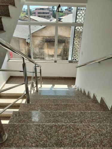 a staircase in a building with a large window at CLASSIC COMFORT Lodge in Mangalore