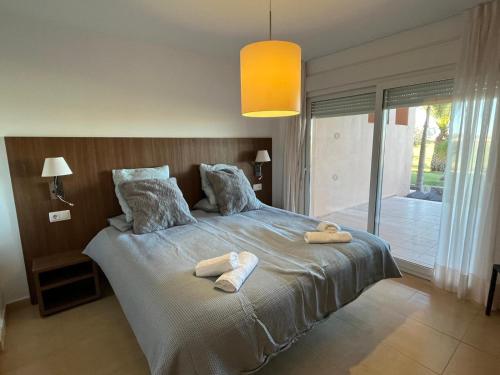 a bedroom with a large bed with towels on it at Beautiful 2 Bed Apartment Mar Menor Golf Resort in Los Martínez