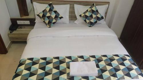 a bedroom with a bed with a checkerboard pattern at Hotel Neu-Nest inn in Rishīkesh