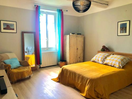 une chambre avec un lit, une chaise et une fenêtre dans l'établissement Le 140 du Ventoux, à Saint-Saturnin-lès-Avignon