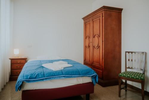 a bedroom with a bed and a wooden cabinet and a chair at Casa Accademia in Venice