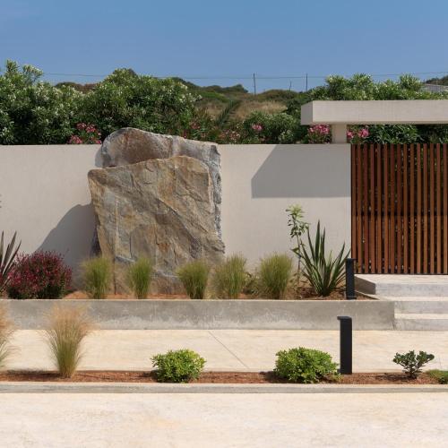 a garden with a large rock and some plants at Marae Villa in Skaleta