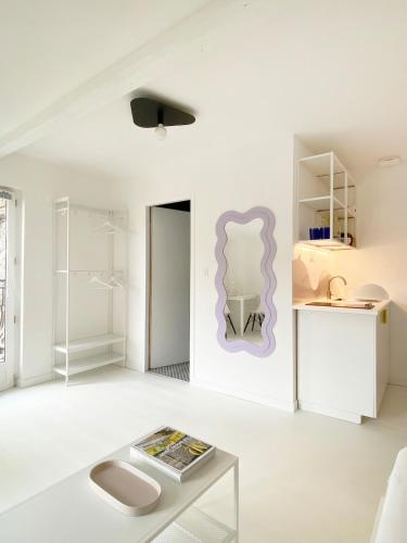 - un salon blanc avec une table et un miroir dans l'établissement Joli studio vue sur Saône, à Caluire-et-Cuire