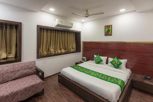 a bedroom with a bed and a couch in it at Treebo Shembekars Inn in Nagpur