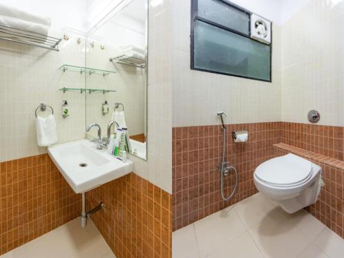 a bathroom with a toilet and a sink at Treebo Shembekars Inn in Nagpur