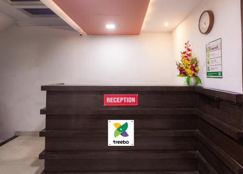 a reception desk with a redhibition sign and a vase of flowers at Treebo Shembekars Inn in Nagpur