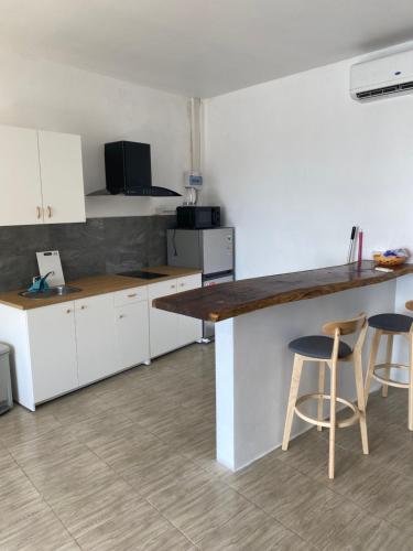 a kitchen with white cabinets and two bar stools at Alice house in Ko Bu Bu