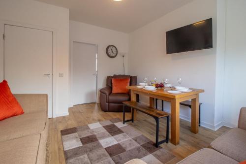 a living room with a table and a couch at Kerr Apartment-Spacious 4-Bed Flat in Hamilton, Close to Glasgow in Cadzow