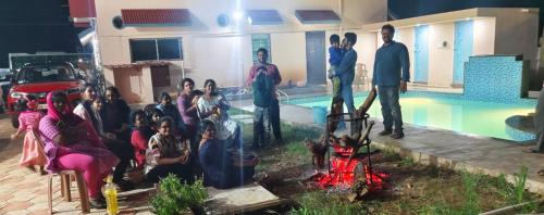 a group of people standing near a swimming pool at Breeze valley Residency in Yelagiri