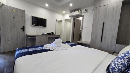 a bedroom with a white bed with a flower on it at Hotel Akshaya in Port Blair
