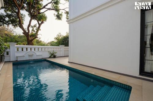 a swimming pool in the backyard of a house at StayVista at Casa PuMa with Pool & WiFi in Camorlim