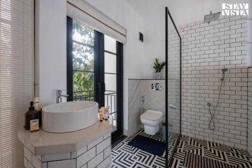 a bathroom with a sink and a toilet at StayVista at Casa PuMa with Pool & WiFi in Camorlim