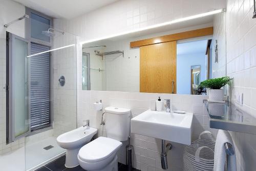 Un baño blanco con inodoro y lavabo. en Apartment in the heart of nature near Seville with swimming pool and parking, en Espartinas