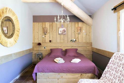 - une chambre dotée d'un lit avec des draps violets et un miroir dans l'établissement L’Ecrin de Nature A haven of peace in the heart of Provence, à Saint-Saturnin-lès-Apt