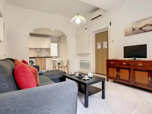 un salon avec un canapé, une télévision et une table dans l'établissement Nestor&Jeeves - BELA VISTA - Central - Near Beach, à Nice