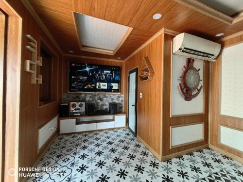 a hallway of a home with a television and a tile floor at Homestay nhà gỗ Lan Anh in Phú Thọ