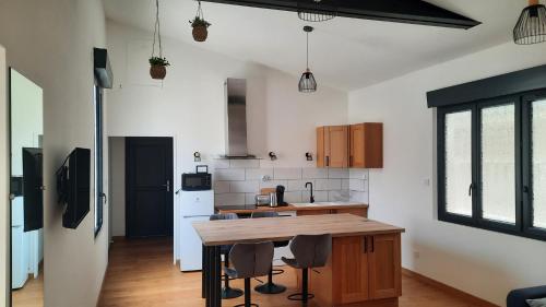 une cuisine avec une table et des chaises dans une pièce dans l'établissement Le Corneroche, à Montélimar