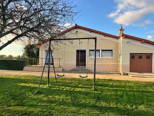 une balançoire dans une cour devant une maison dans l'établissement Chez Yvonne, à Neuf-Église
