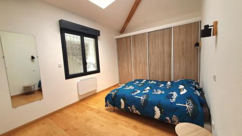 une chambre avec un lit bleu et une fenêtre dans l'établissement Le Corneroche, à Montélimar