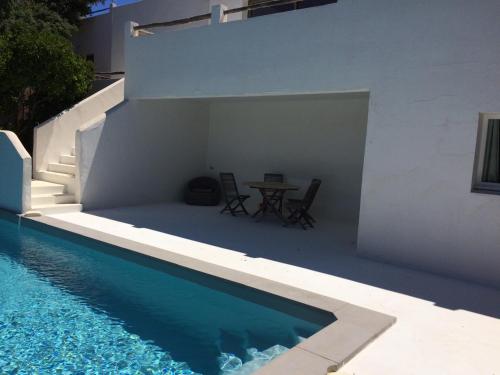 une maison blanche avec une table et une piscine dans l'établissement Villa Taru Pinarello, à Mangialla
