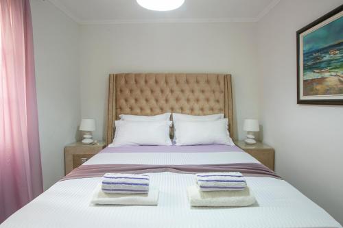 a bedroom with a bed with two towels on it at Luxury Apartments Montesan in Sveti Stefan