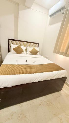 a bedroom with a large bed with white sheets and pillows at Vaaraahi Hotels in Hyderabad