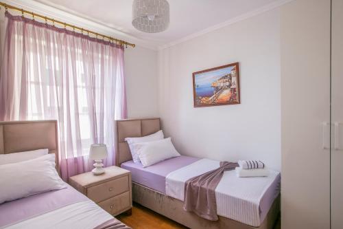 a bedroom with two beds and a window at Luxury Apartments Montesan in Sveti Stefan
