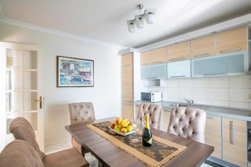 a kitchen with a wooden table with a bowl of fruit at Luxury Apartments Montesan in Sveti Stefan