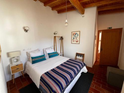 a bedroom with a bed and a wooden ceiling at Casas de Santa Rita in Évora Monte