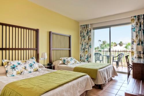 
a bedroom with two beds and a window at PortAventura Hotel Caribe - Includes PortAventura Park Tickets in Salou
