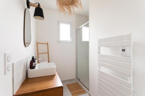 a bathroom with a sink and a mirror at La Belle de Fréhel - Jolie maison avec jardin in Frehel