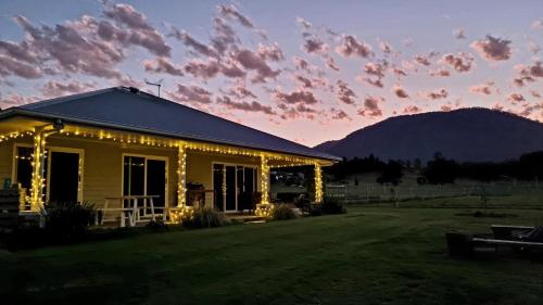 a house decorated with christmas lights in a field at Fig Tree Farm B&B Highvale-Farmstay near Brisbane! in Highvale