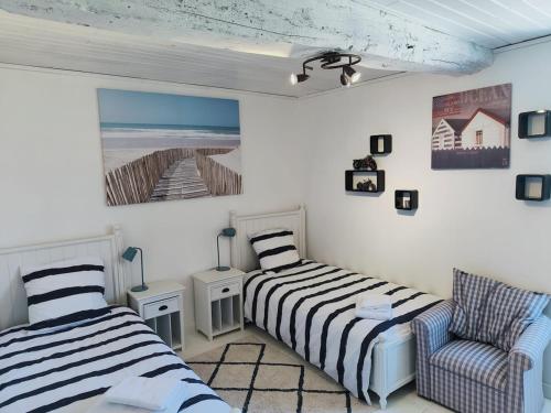 - une chambre avec deux lits, une chaise et un tableau dans l'établissement Le Clos Lagrange-10 pers-Piscine privée, à Varaignes