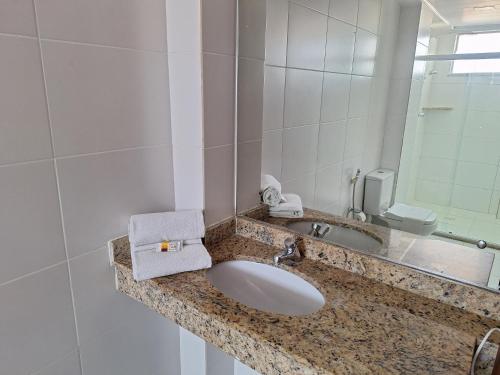 a bathroom with a sink and a mirror at Alto da Praia Hotel in Aracaju