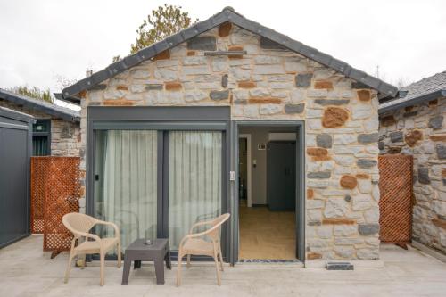 a stone house with two chairs and a table at Ağva Casa Rosa Bungalov Otel in Sile