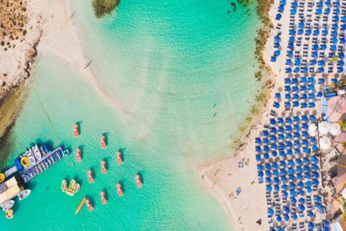 an overhead view of a beach with umbrellas and boats at Villa Olympia in Nea Dimmata